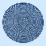 Single blue round woven polyester placemat centered on a softly tinted pale blue studio background.