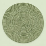 Single green round woven polyester placemat centered on a softly tinted pale green studio background.