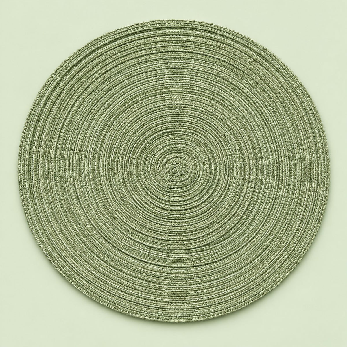 Single green round woven polyester placemat centered on a softly tinted pale green studio background.