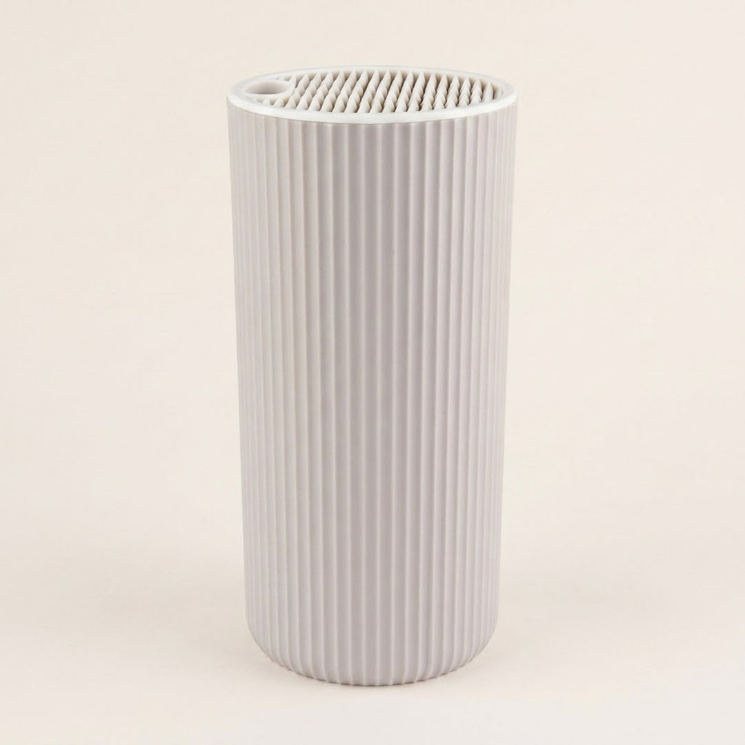 A light gray ribbed cylindrical filter cartridge with a slotted top opening, shown against a solid off-white background.
