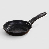 A black non-stick frying pan with white speckled pattern and a black handle, shown on a light gray background.