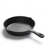 A classic black cast iron skillet with a textured interior and a single loop handle, photographed on a clean white background with a soft shadow.