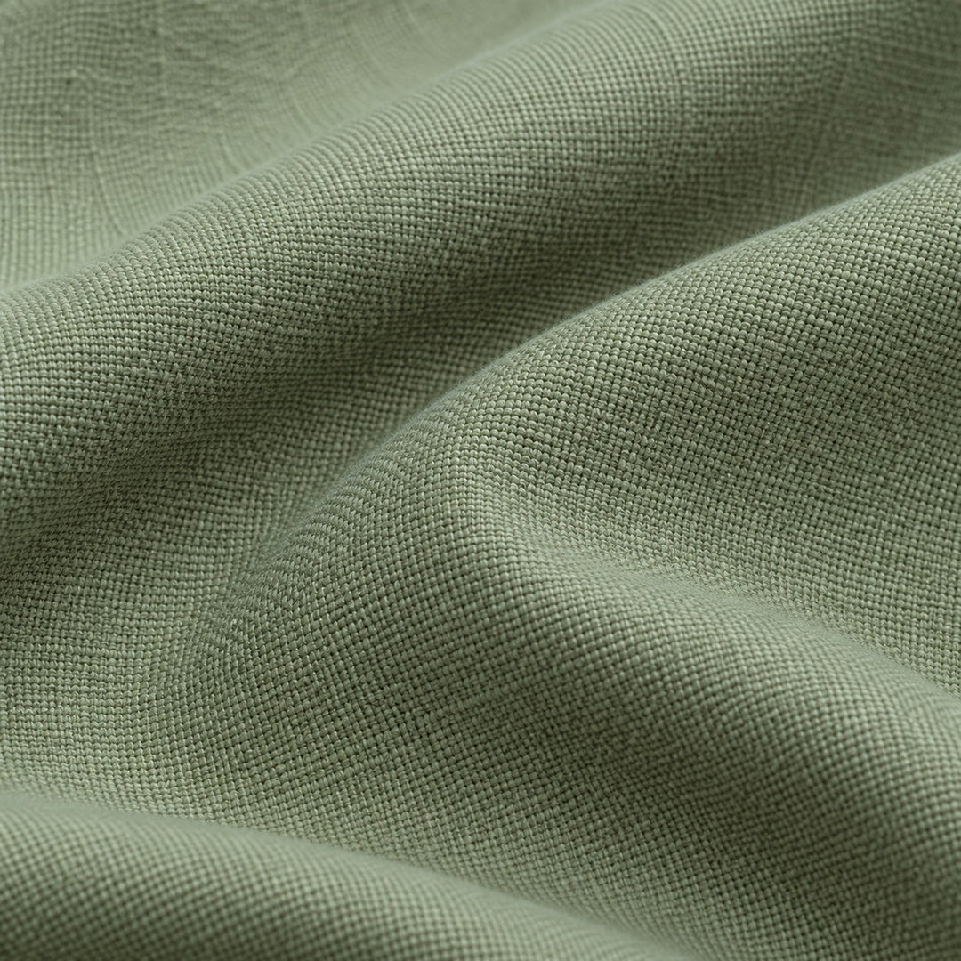 Close view of the sage green polyester tablecloth's fine woven texture and matte finish.
