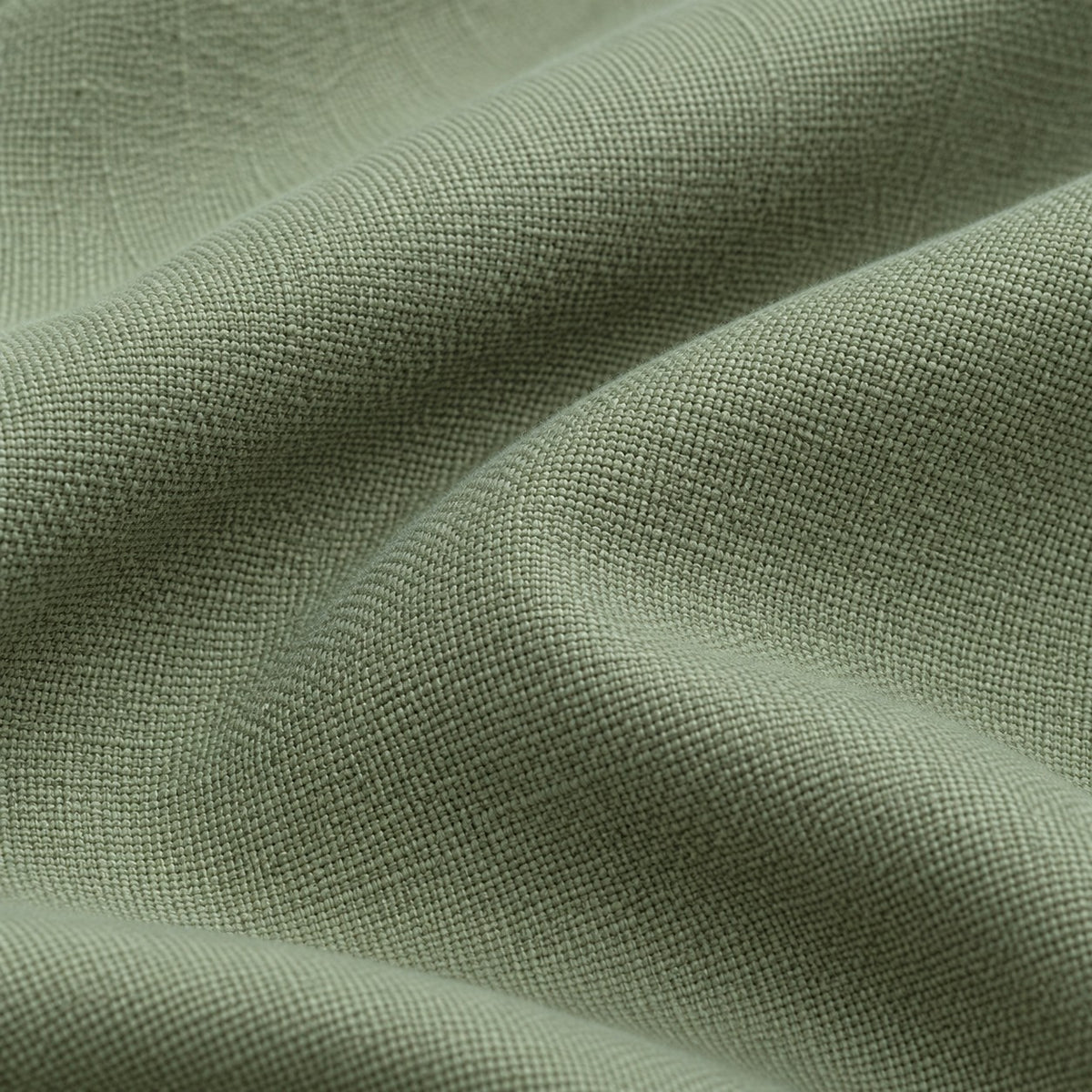 Close view of the sage green polyester tablecloth's fine woven texture and matte finish.