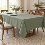 Sage green polyester tablecloth covers a dining table with visible side and end overhang.