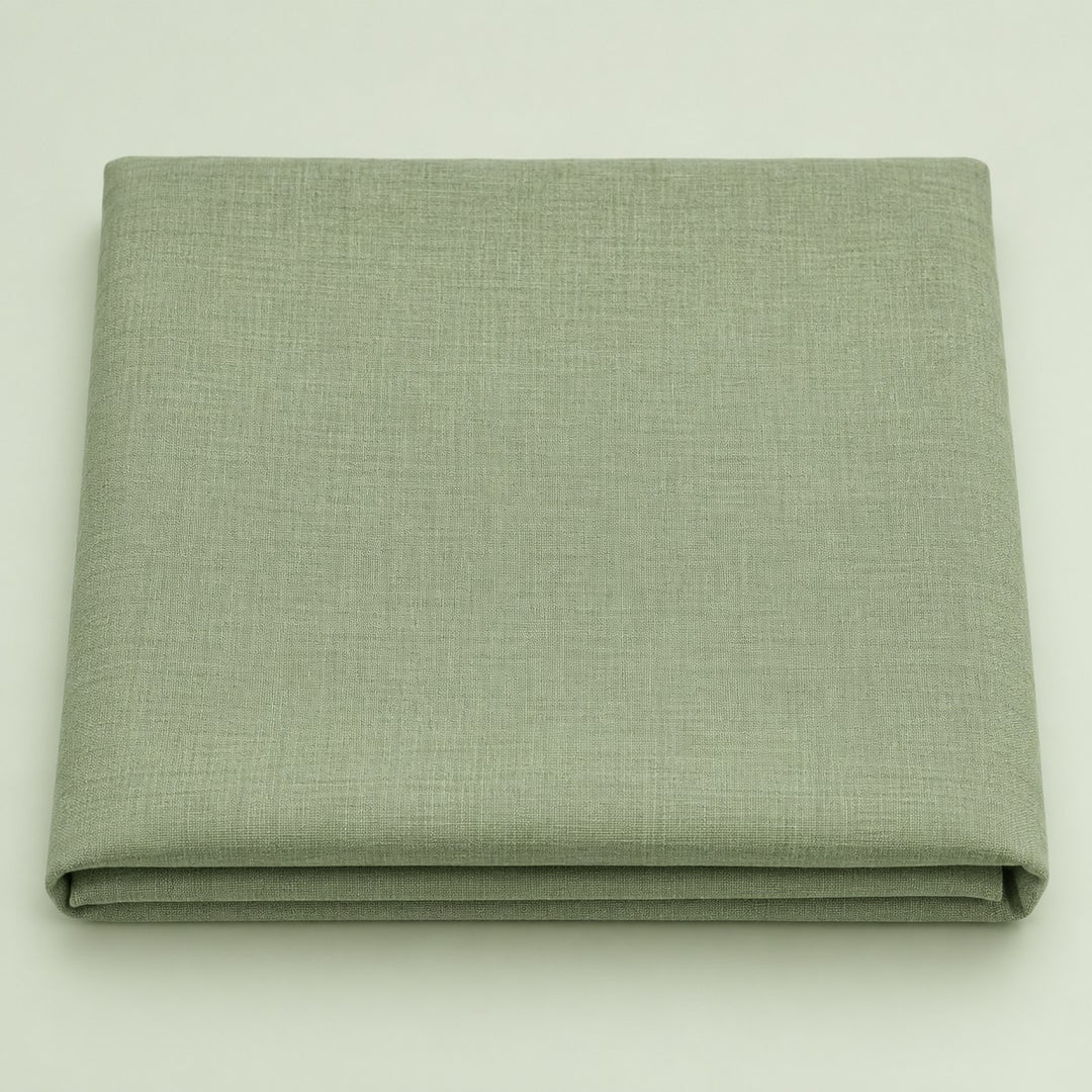 Folded sage green polyester tablecloth centered on a soft sage studio background.