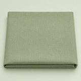 Folded sage green polyester tablecloth centered on a soft sage studio background.
