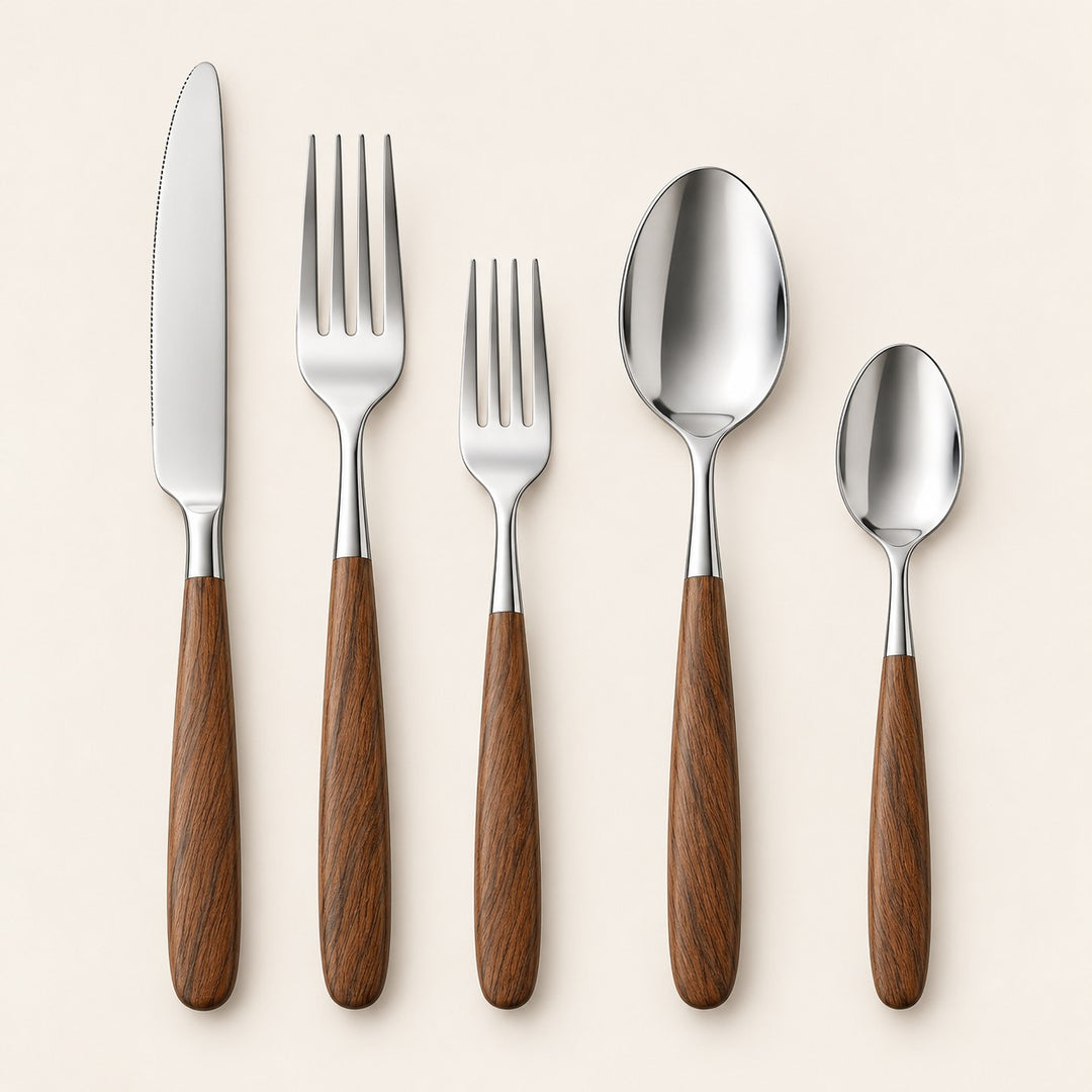 Brown and silver five-piece flatware set with stainless utensils and brown wood-look handles on beige.