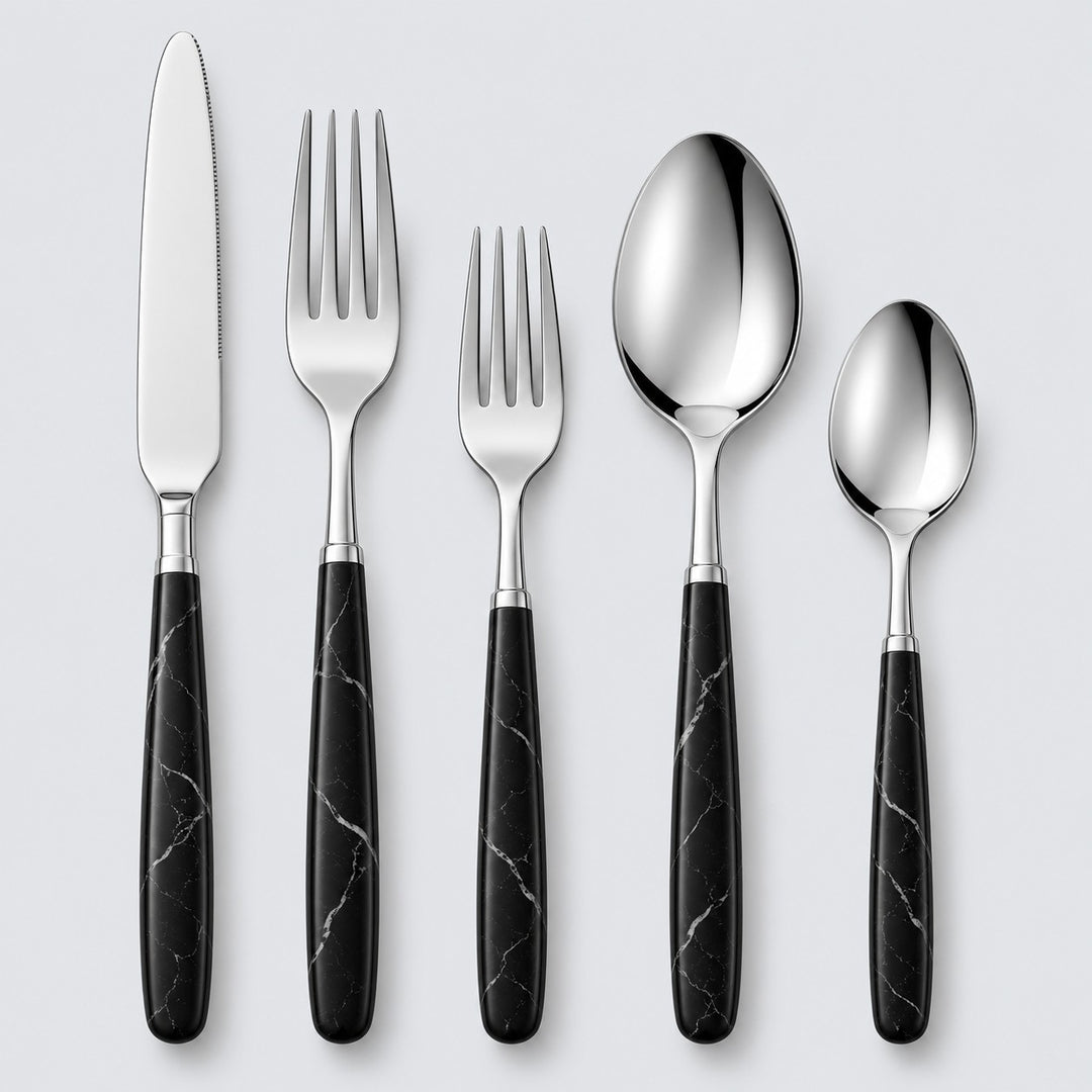 Black and silver five-piece flatware set with stainless utensils and veined black handles on gray.