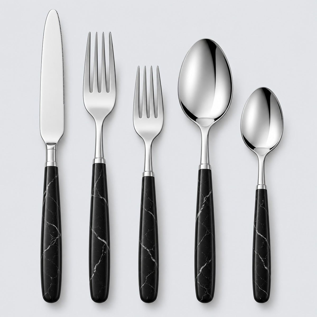 Black and silver five-piece flatware set with stainless utensils and veined black handles on gray.