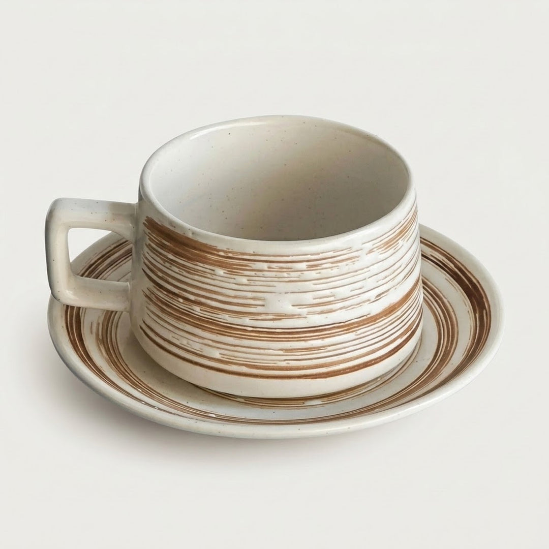 A ceramic coffee cup with a matching saucer, featuring a distressed off-white glaze with horizontal brown stripes, photographed on a clean, light off-white background.
