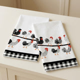 Two white kitchen towels with a rooster pattern and black-and-white gingham borders, displayed on a light beige surface.