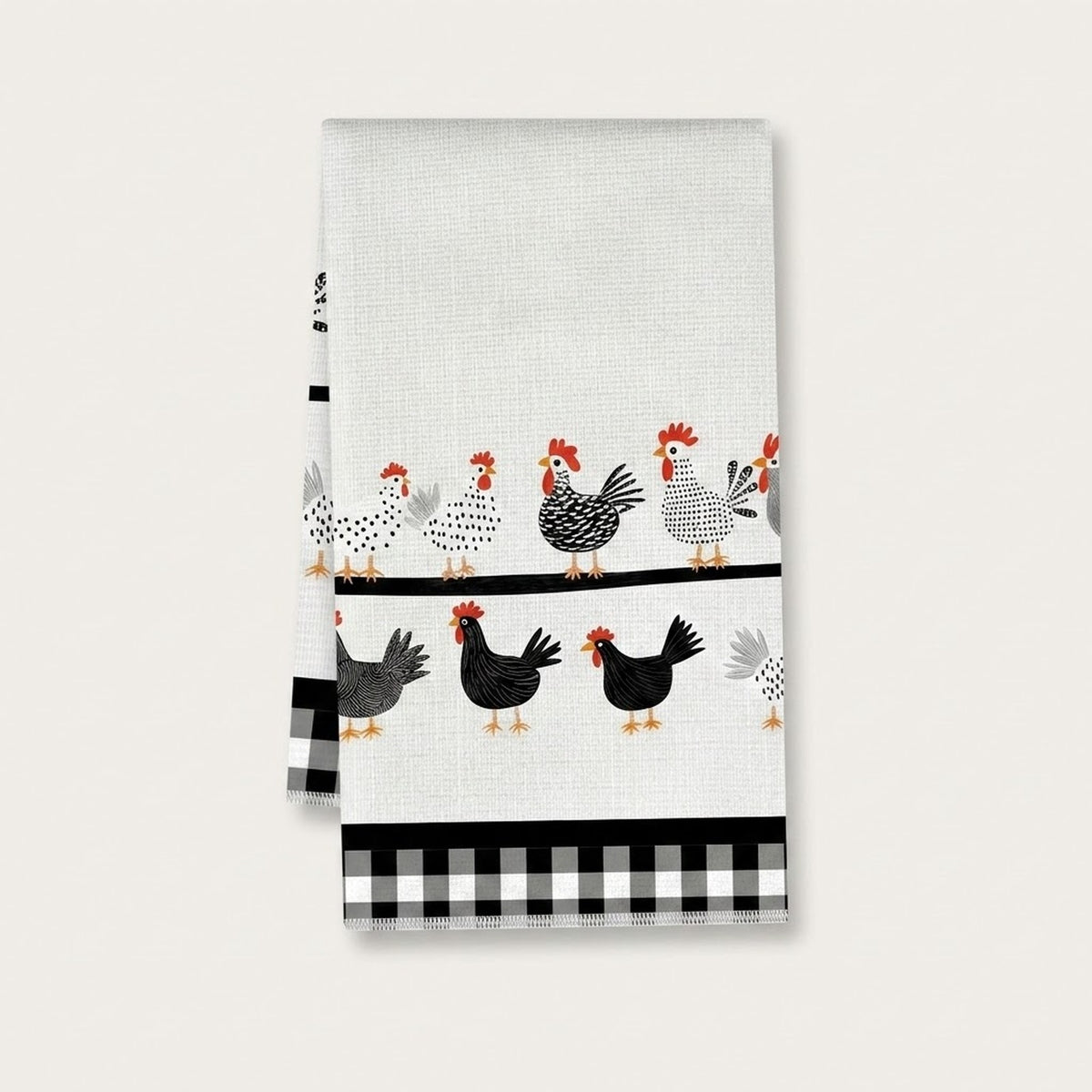 A white kitchen tea towel featuring a pattern of black and white chickens with red combs and yellow beaks, along with a black and white gingham check border at the bottom, shown against a light gray background.