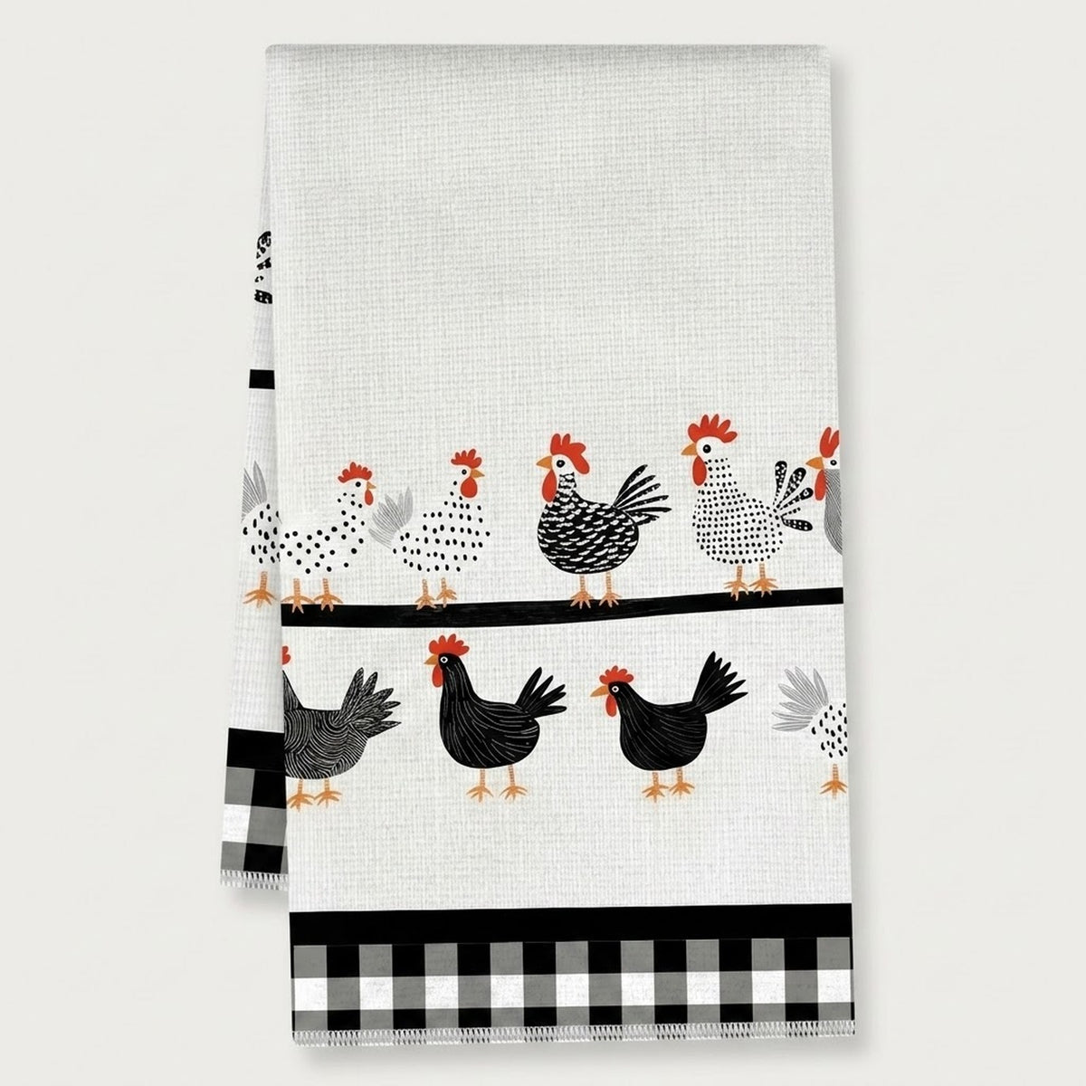 A white kitchen tea towel featuring a pattern of black, white, and red chickens, with a black and white gingham checkered border at the bottom.