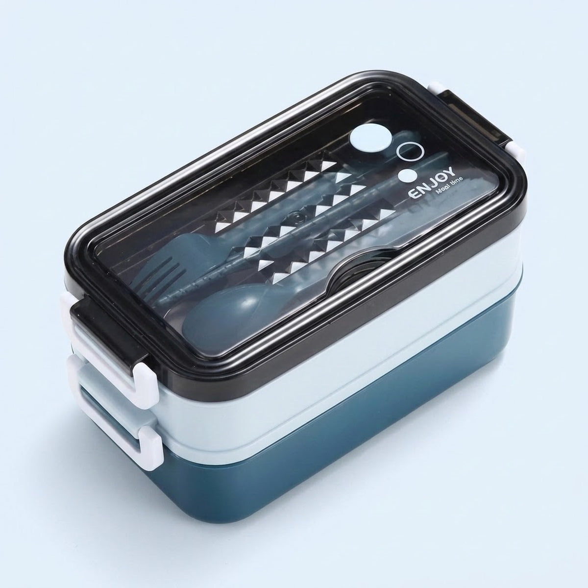 A two-tiered lunch box with a dark blue base, white middle tier, and black lid, featuring a clear window that shows a gray utensil set inside. The lid has a black border, white latches, and the word 'ENJOY' printed on it.