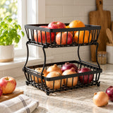 Black Two-Tier Produce Basket organizes apples and onions on a kitchen counter.