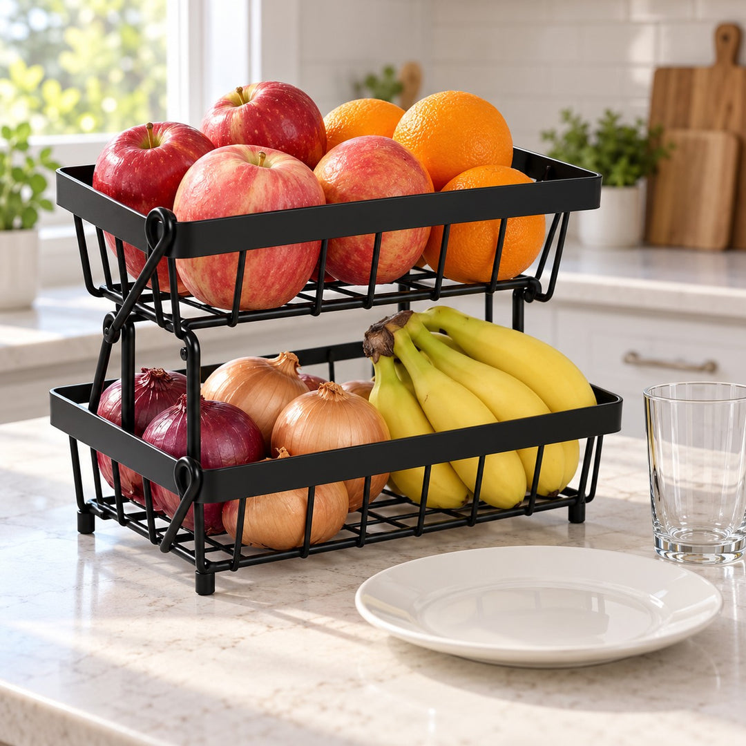 Black Two-Tier Produce Basket holds produce beside a dinner plate and drinking glass.