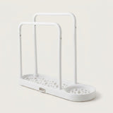 A white plastic double-tier shower caddy with a perforated base and integrated drain tray, shown on a light beige background.