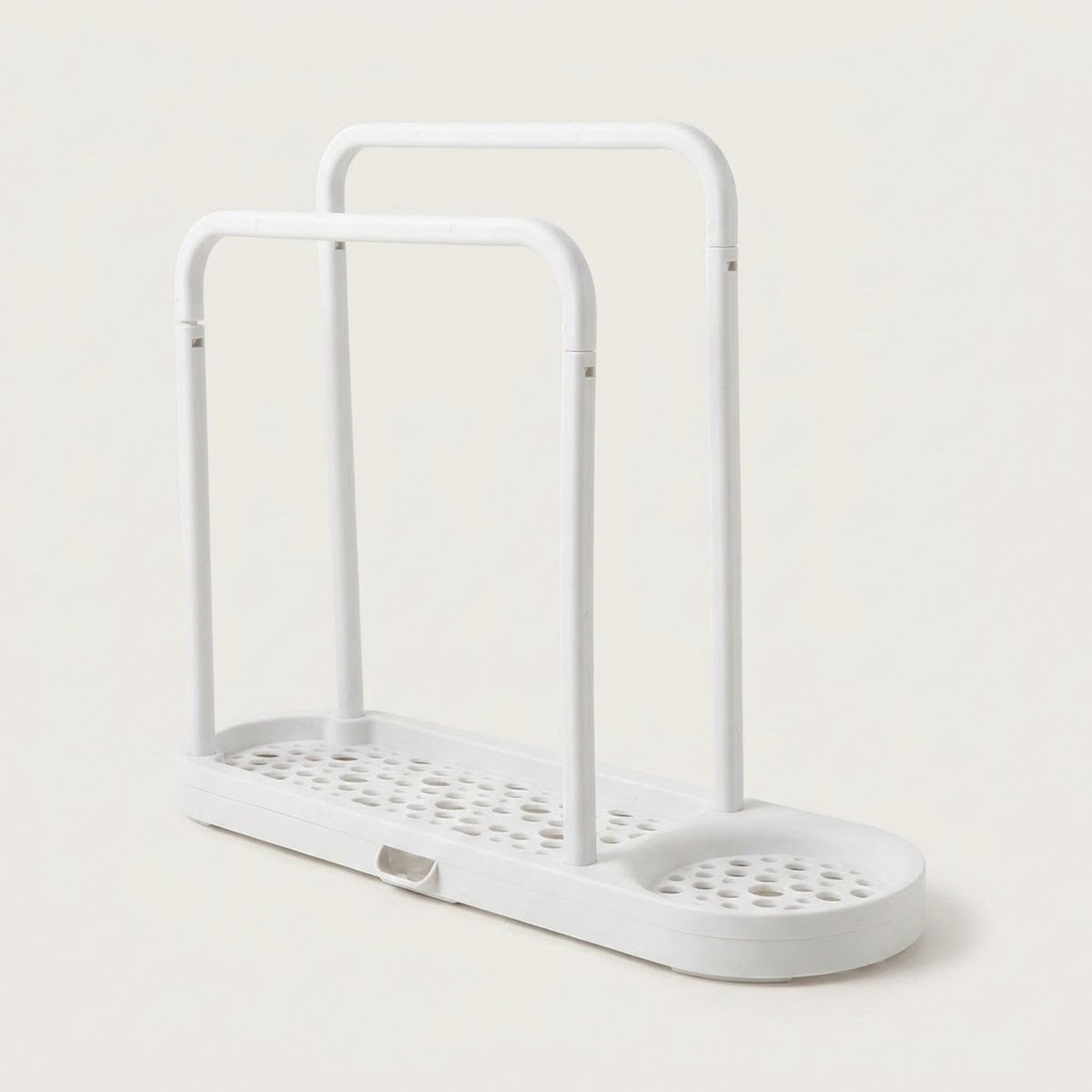 A white plastic double-tier shower caddy with a perforated base and integrated drain tray, shown on a light beige background.