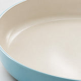 Ceramic Glaze Nonstick Frying Pan close-up showing its smooth ivory glaze and aqua rim.