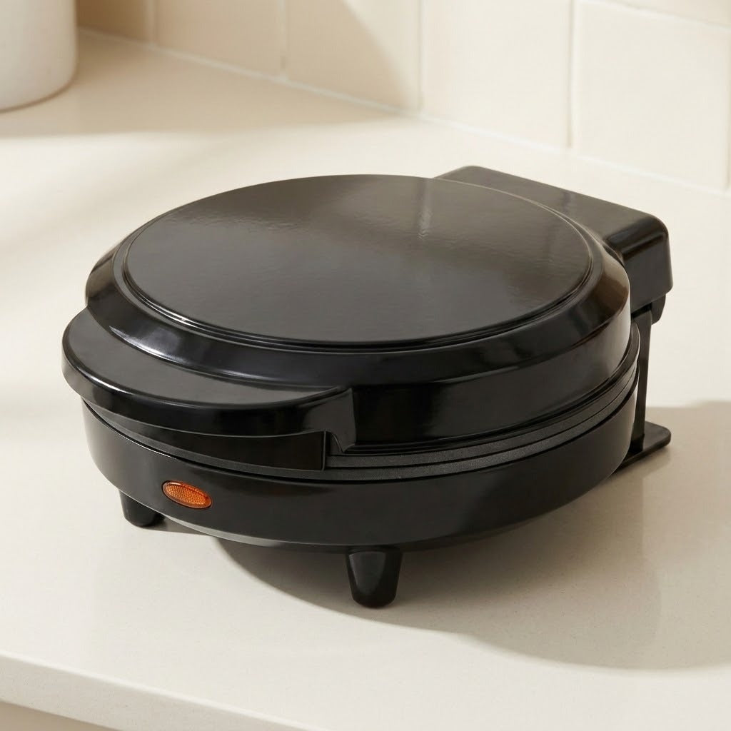 A black waffle maker sitting on a white kitchen countertop with a tiled backsplash in the background.