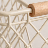 Close view of the beige iron mesh, welded joints and natural wood grip on the wire basket.