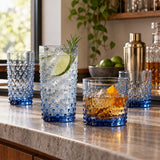 Blue Vintage Hobnail Drinking Glass Set serves cocktails in tall and short glasses on a home bar.