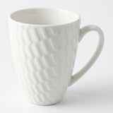 A white ceramic mug with a textured, embossed geometric pattern and a curved handle, shown on a clean white background.