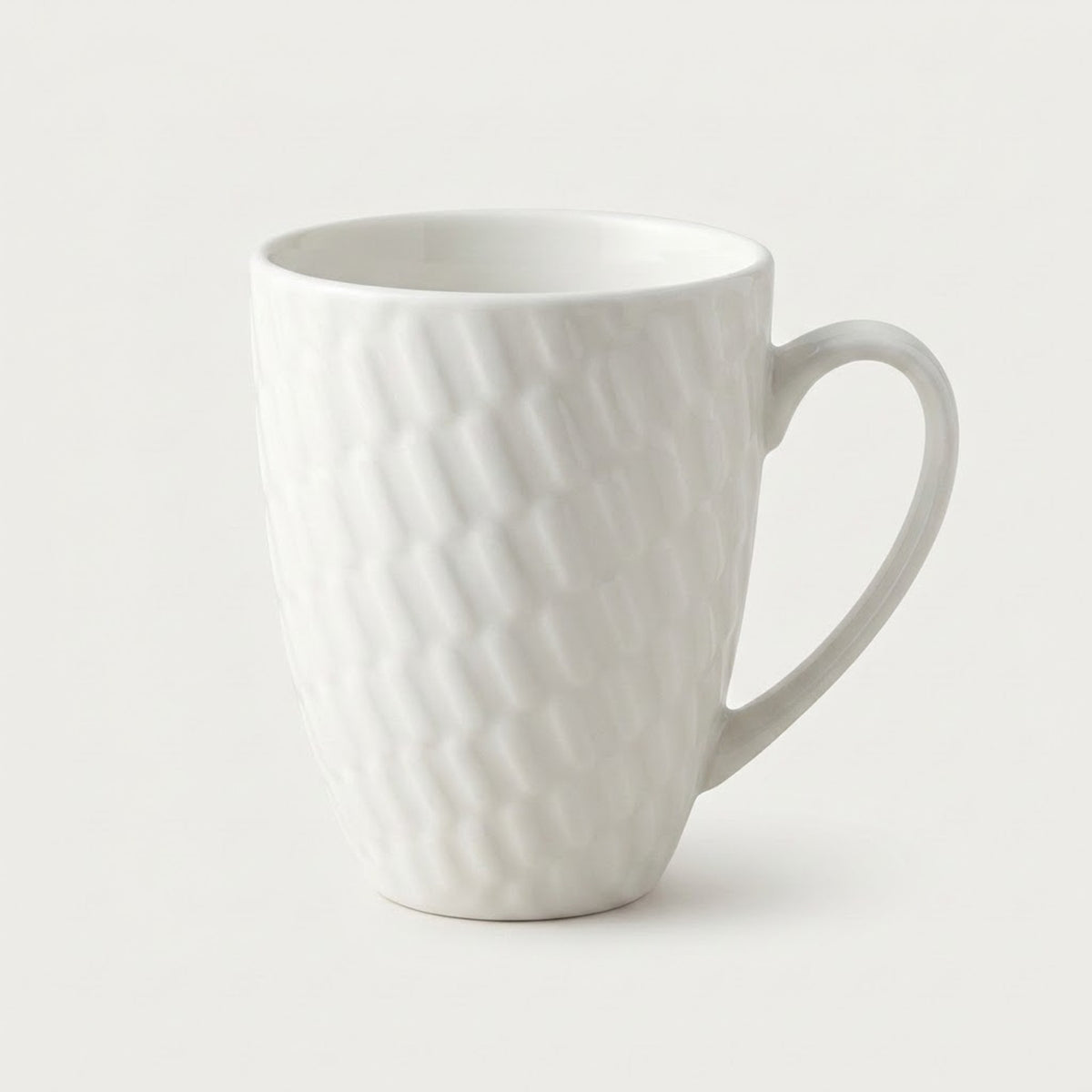 A white ceramic mug with a textured, wavy diamond pattern and a curved handle, shown on a clean, light off-white background.