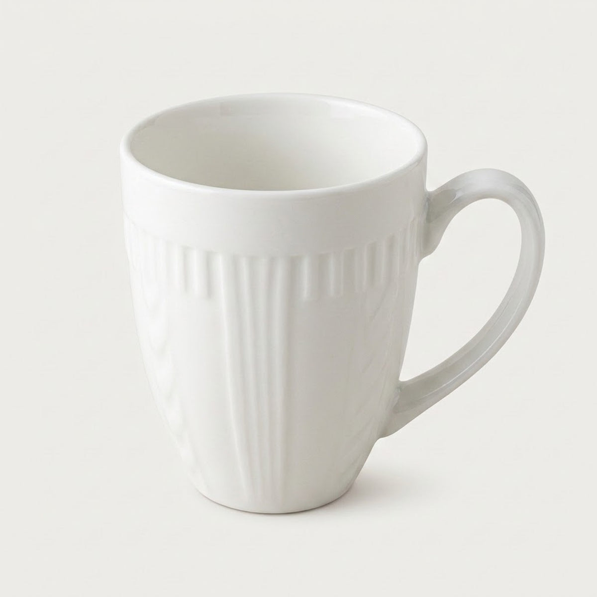 A white ceramic coffee mug with a ribbed vertical texture and a curved handle, shown on a light gray background.
