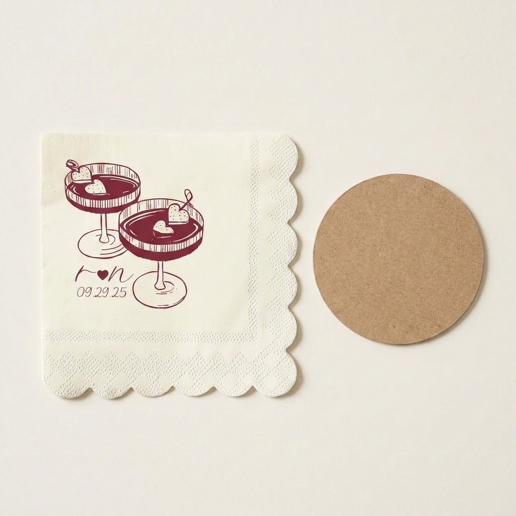 A square off-white paper napkin with scalloped edges, printed with two cocktail glasses and the text 'For 09.29.