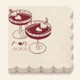 A stack of square paper napkins with scalloped edges, printed with an illustration of two heart-themed cocktails and the date '09.29.