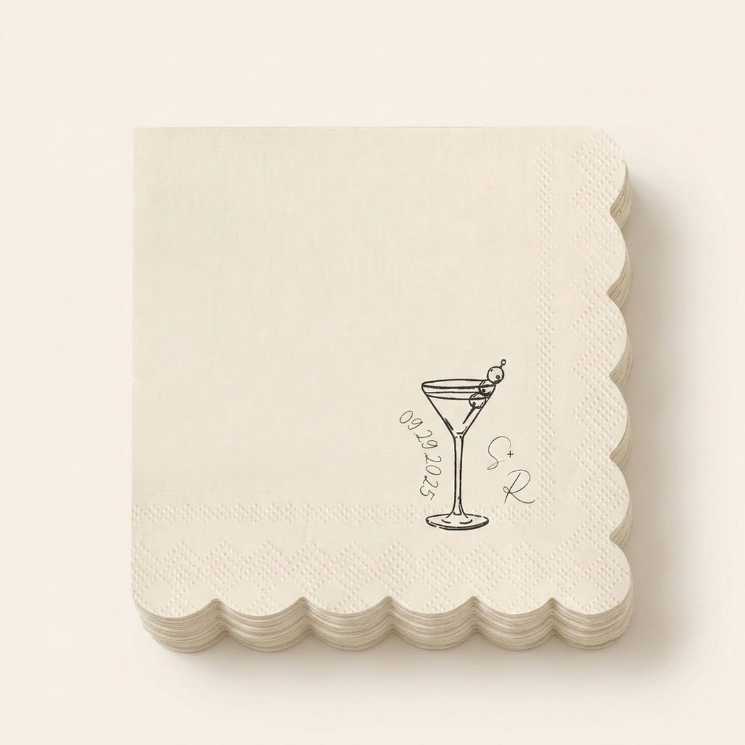 A stack of square off-white paper napkins with scalloped edges, featuring a black line art illustration of a martini glass with an olive, the date '09.28.