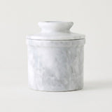A small cylindrical lidded jar or container with a white marble-look surface and soft gray veining, photographed on a clean white background.