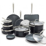 A 16-piece nonstick cookware set in matte black with stainless steel handles and glass lids, arranged on a clean white background.