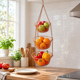 Copper Three Tier Hanging Fruit Basket beside a plate shows its graduated basket sizes and capacity.