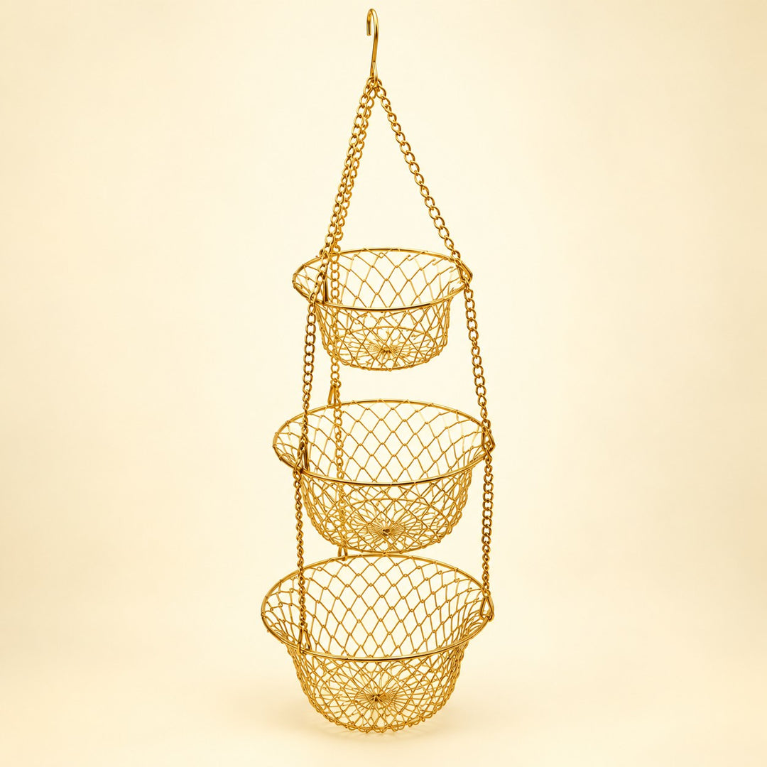 Gold Three Tier Hanging Fruit Basket hangs assembled against a pale gold studio background.