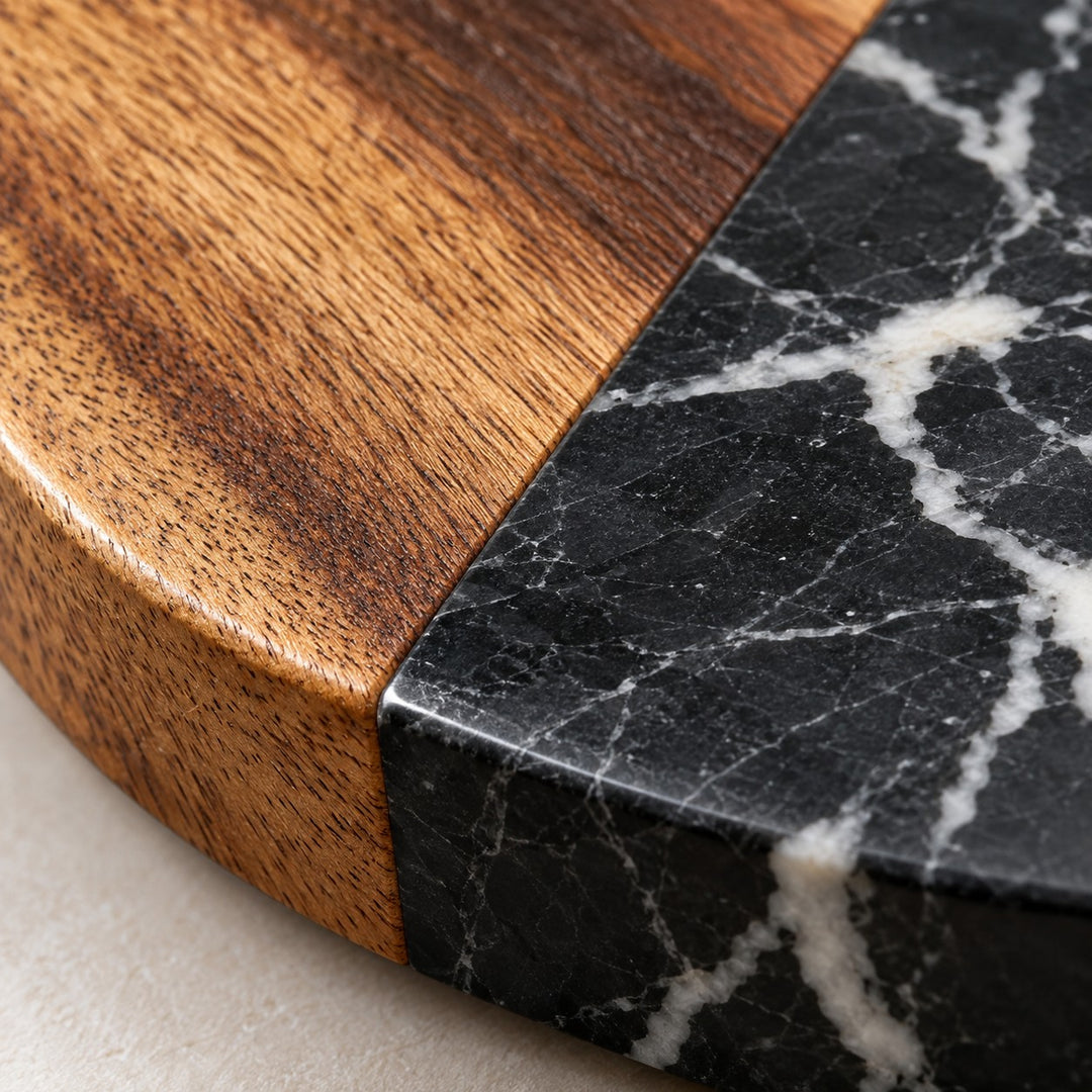 Close detail of acacia grain beside polished marble veining on the coaster surface.