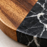 Close detail of acacia grain beside polished marble veining on the coaster surface.