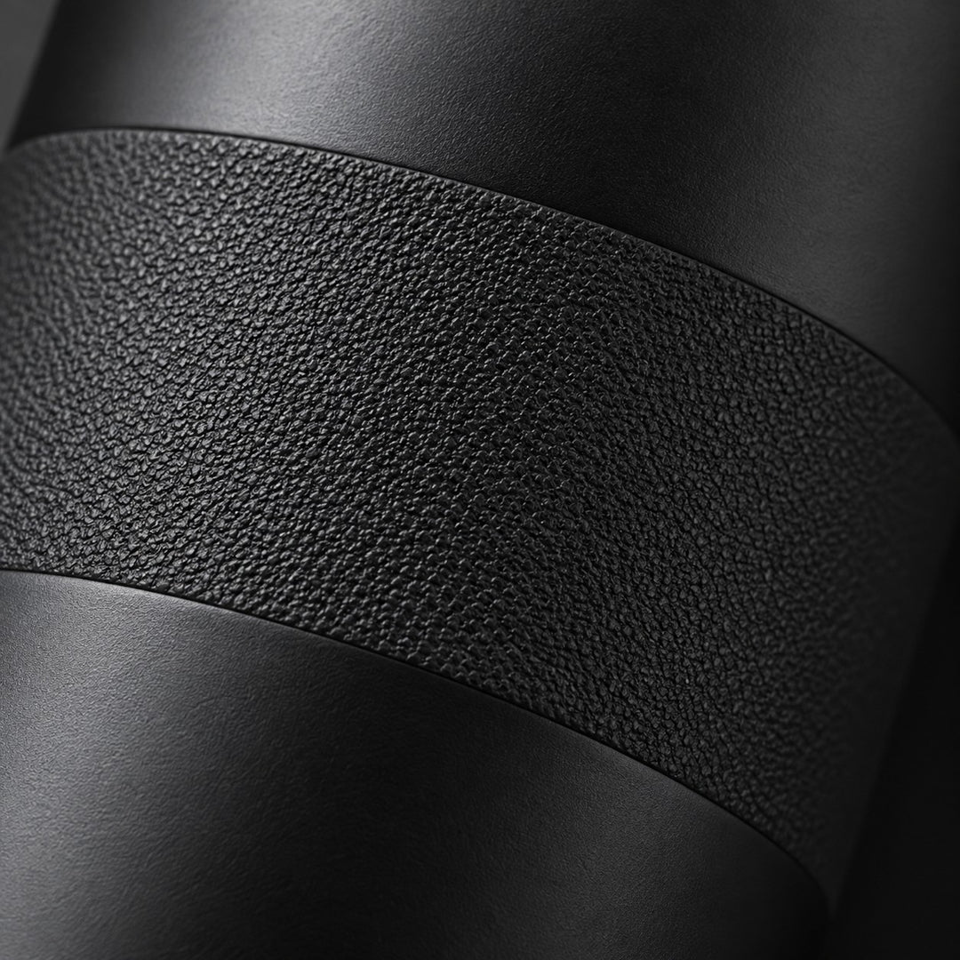 Macro view of the black bottle's matte stainless steel finish and textured grip surface.