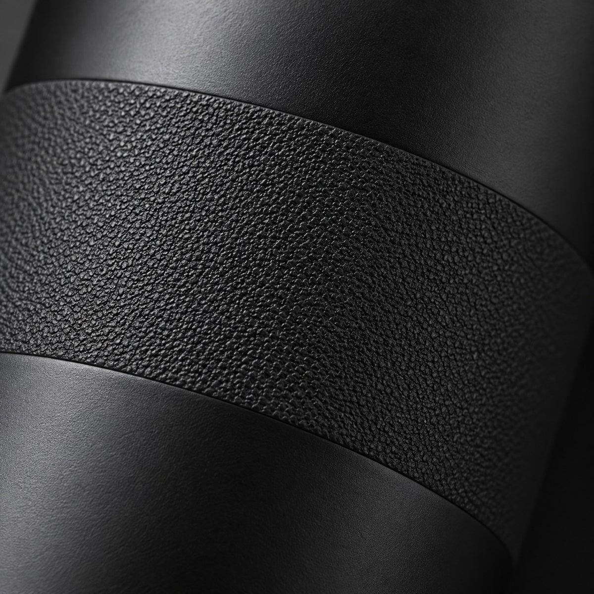 Macro view of the black bottle's matte stainless steel finish and textured grip surface.