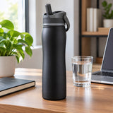 Black 24 oz insulated straw bottle stands on a home office desk for spill-conscious sipping during work.