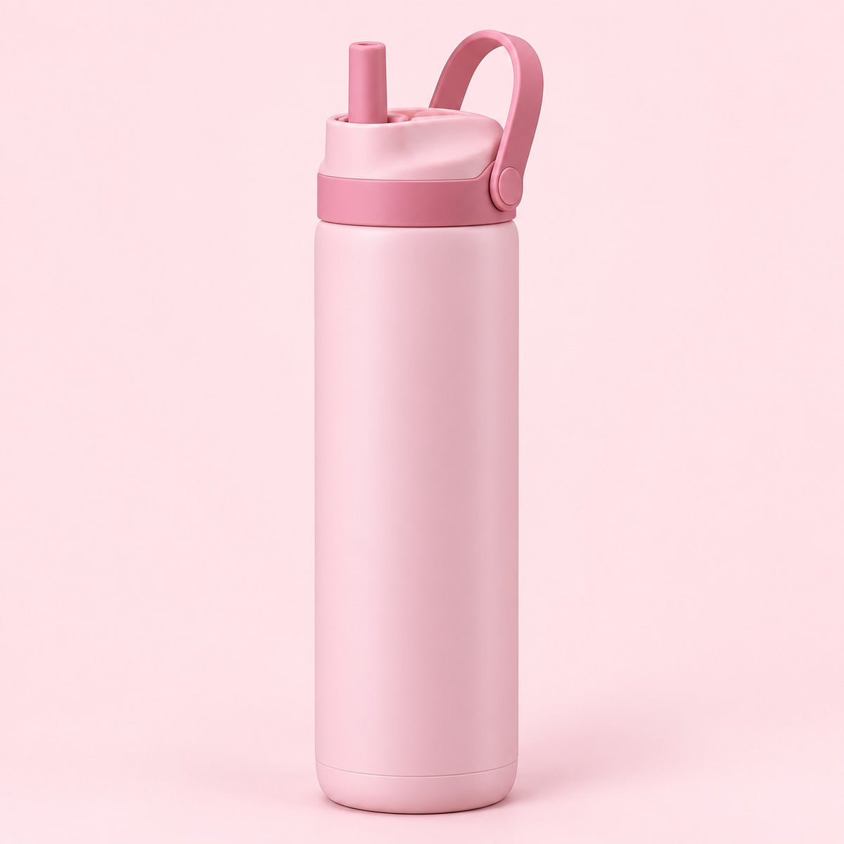 Pink 24 oz insulated straw bottle with raised carry loop against a pale blush background.