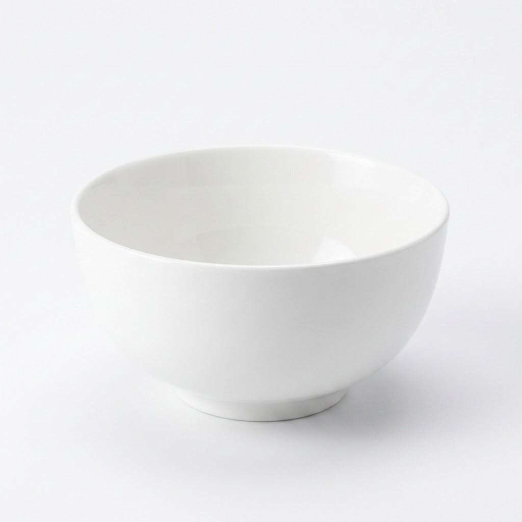 A minimalist white ceramic bowl with a smooth, matte finish, photographed on a seamless white background.