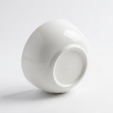 A glossy white ceramic bowl shown from a side angle on a clean white background.