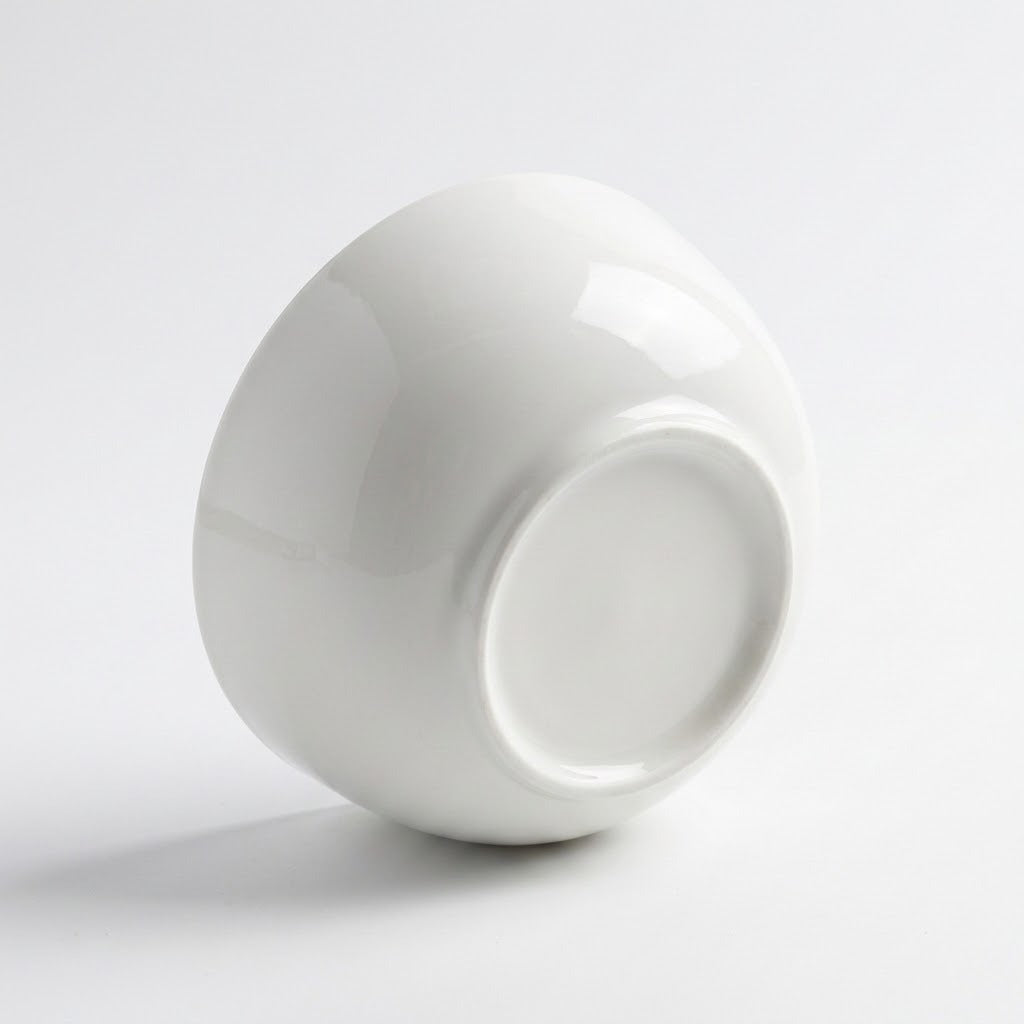 A glossy white ceramic bowl shown from a side angle on a clean white background.