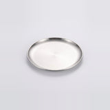 A round silver metal tray with a brushed finish and a raised rim, photographed on a clean light gray background.