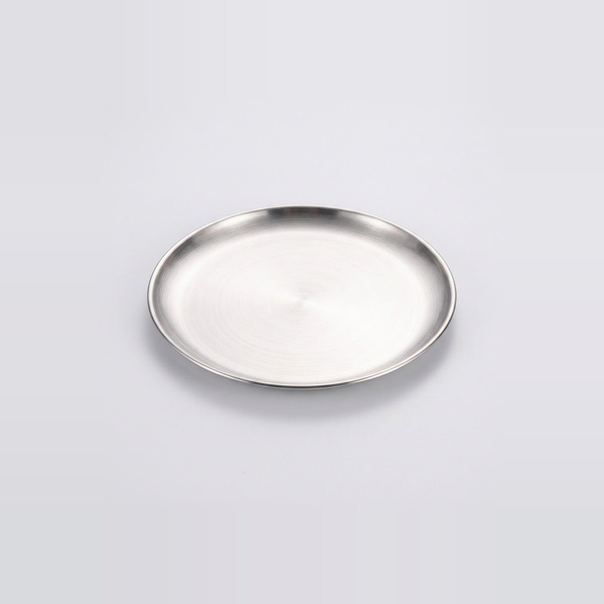 A round silver metal tray with a brushed finish and a raised rim, photographed on a clean light gray background.