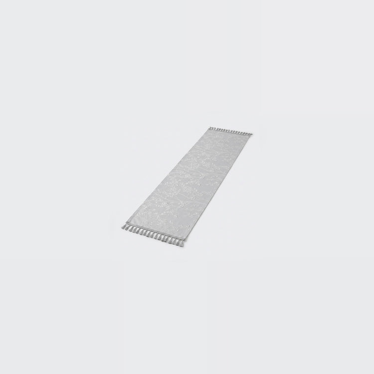 A long, narrow rectangular gray textured strip with small white zigzag cutouts along both short ends, shown on a plain light gray background.