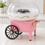 Pink cotton candy maker with vintage cart styling, black spoked wheels, gold trim, and a clear dome.